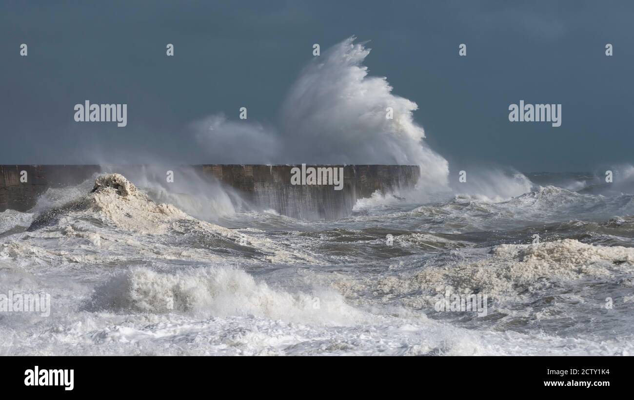 Onde tempeste che si infrangono sul braccio portuale e sul faro di Newhaven, East Sussex, UK Foto Stock