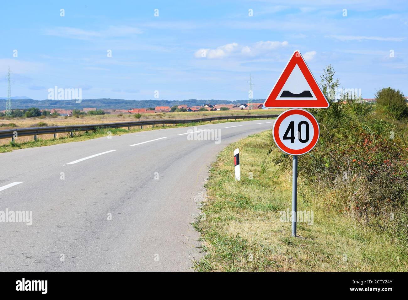 Segnaletica stradale che avvisa il conducente della velocità massima di 40 chilometri per ora e ammaccatura sulla strada Foto Stock