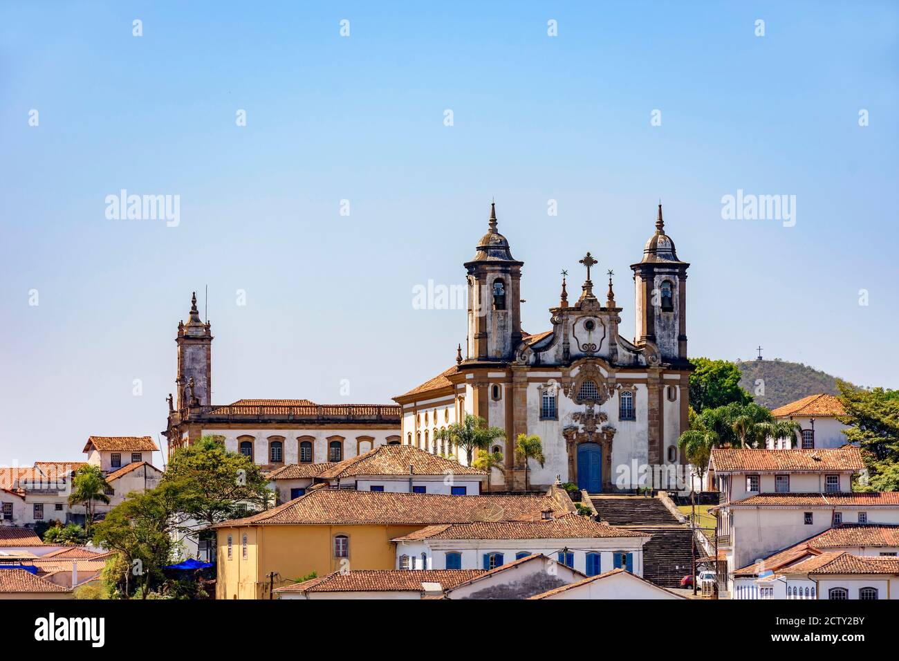 Vista dal basso del centro storico di Ouro Preto con le sue case, la chiesa, i monumenti e le montagne Foto Stock