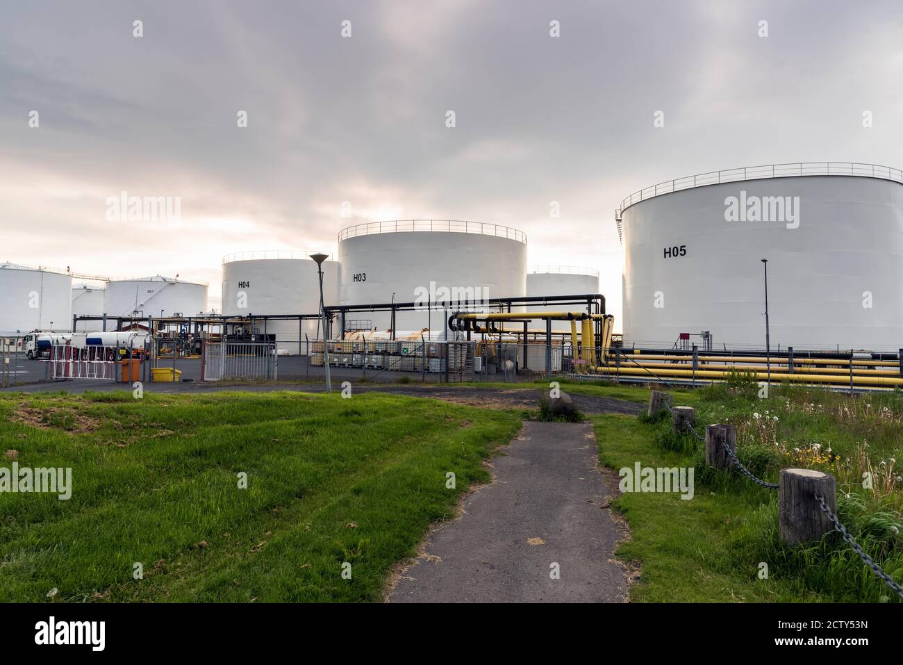 Serbatoi di stoccaggio dell'olio in un'area industriale al tramonto Foto Stock