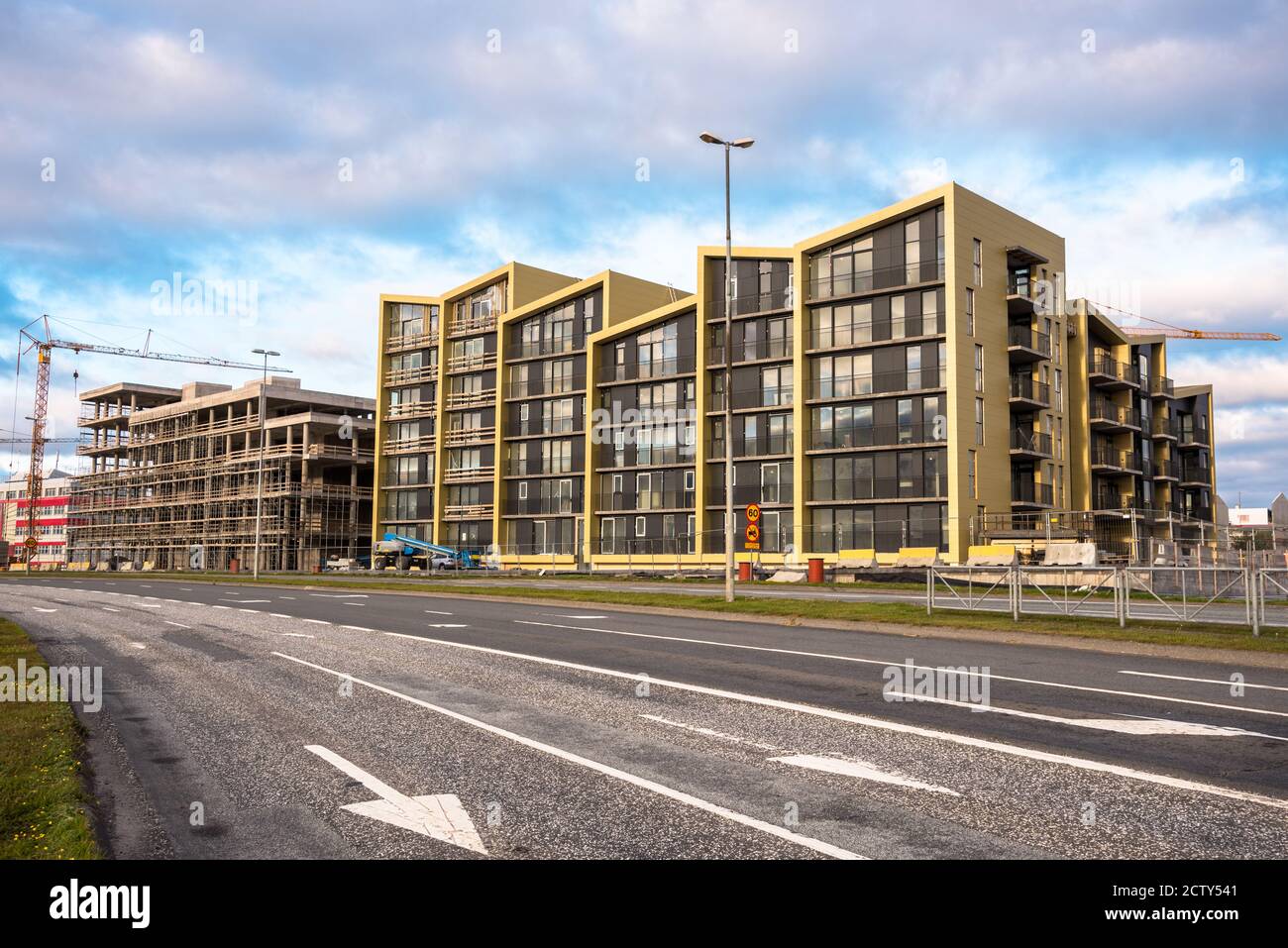 Complesso di appartamenti in costruzione lungo una strada urbana importante a. tramonto Foto Stock