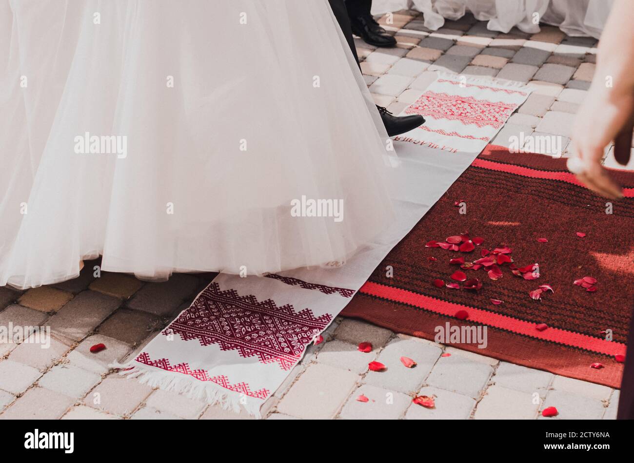 La sposa e lo sposo prendono un passo su bianco nazionale asciugamani Foto Stock