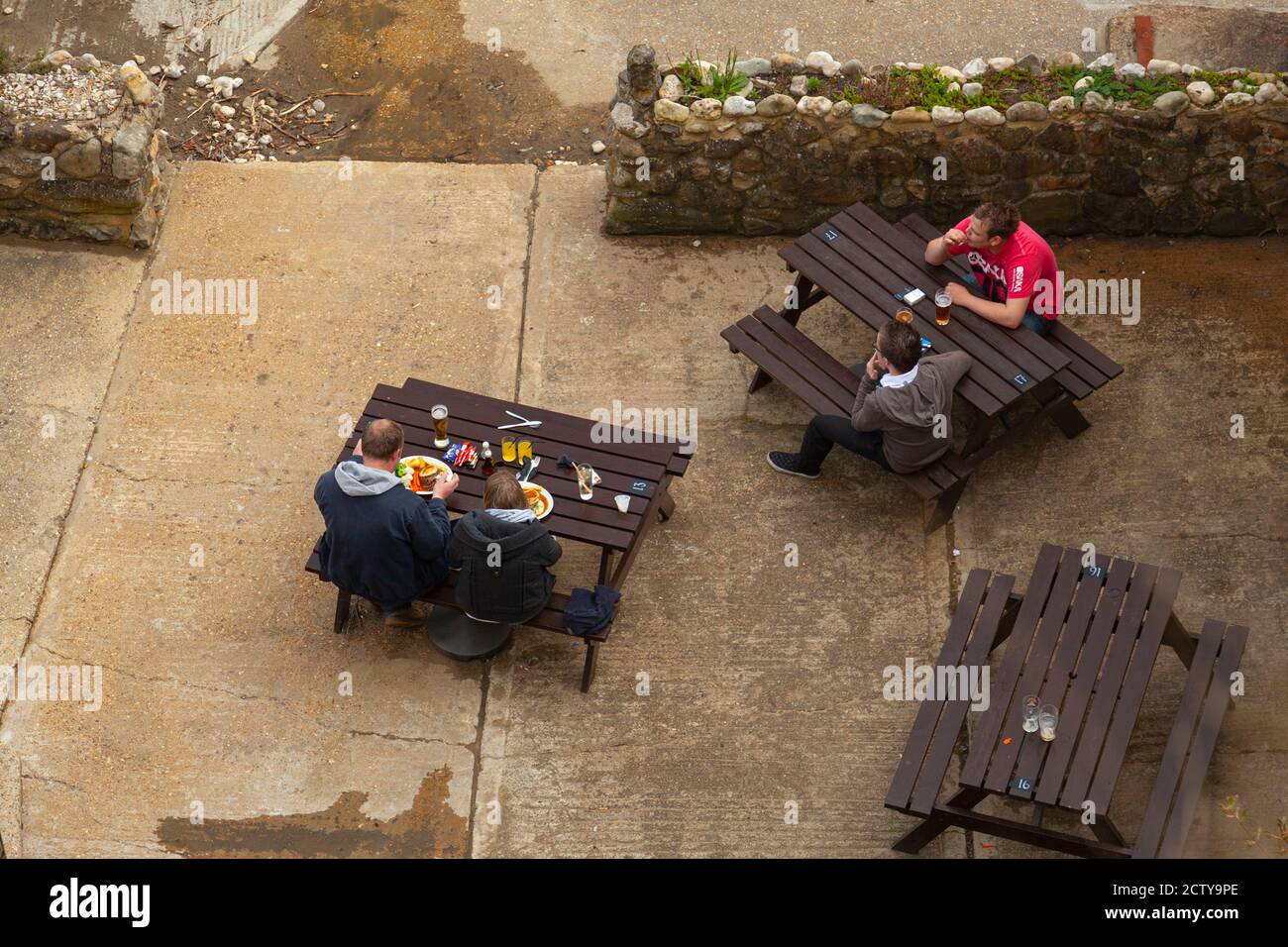 Isle of Wight, 04/25/2010: Una coppia, un padre e un figlio si vedono mangiare in un pub locale. E' posto a sedere all'aperto a tavoli da picnic in legno posti sul confr Foto Stock