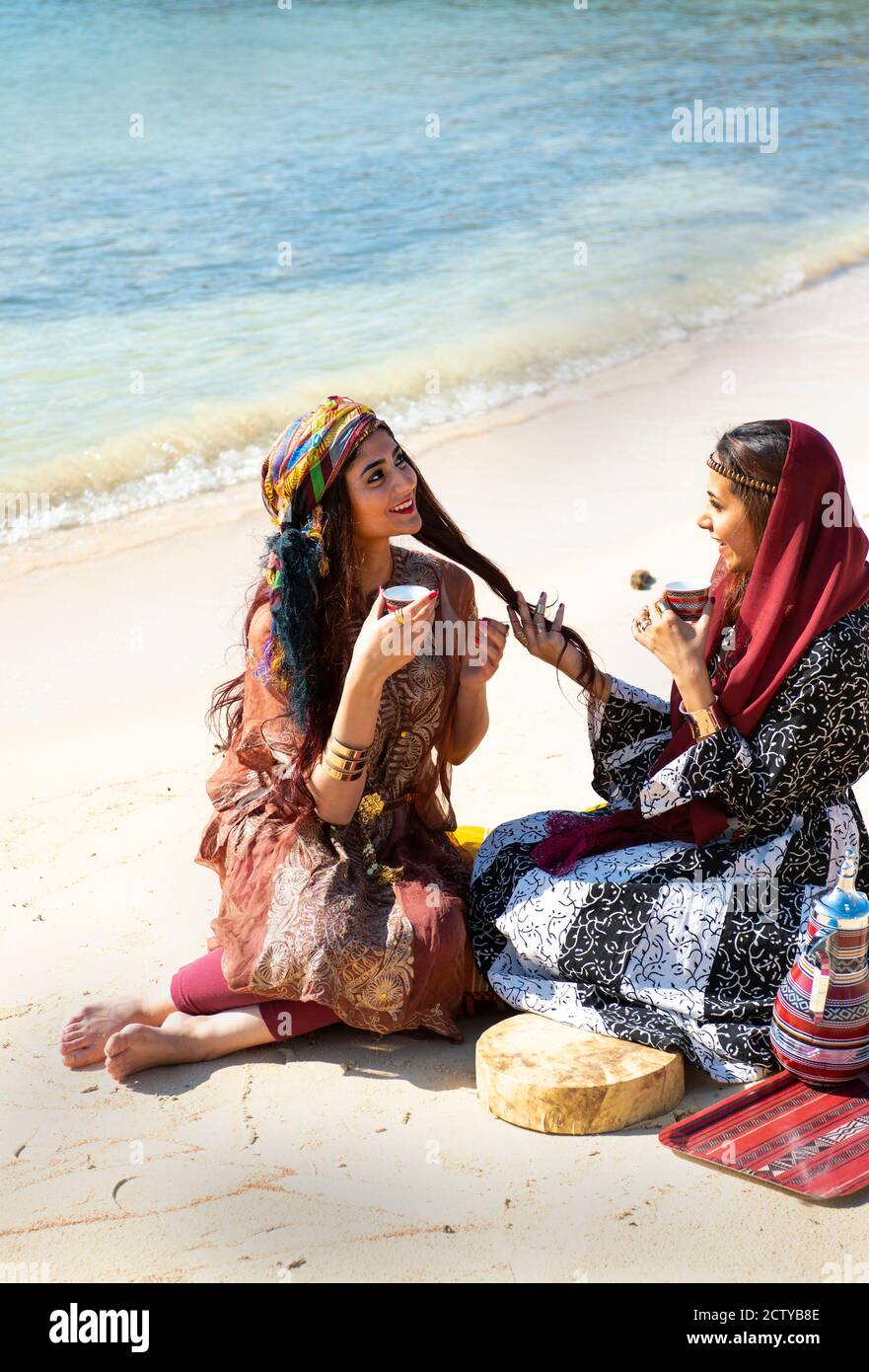 Donne in spiaggia in Arabia Saudita bere tè arabo spiaggia Foto Stock
