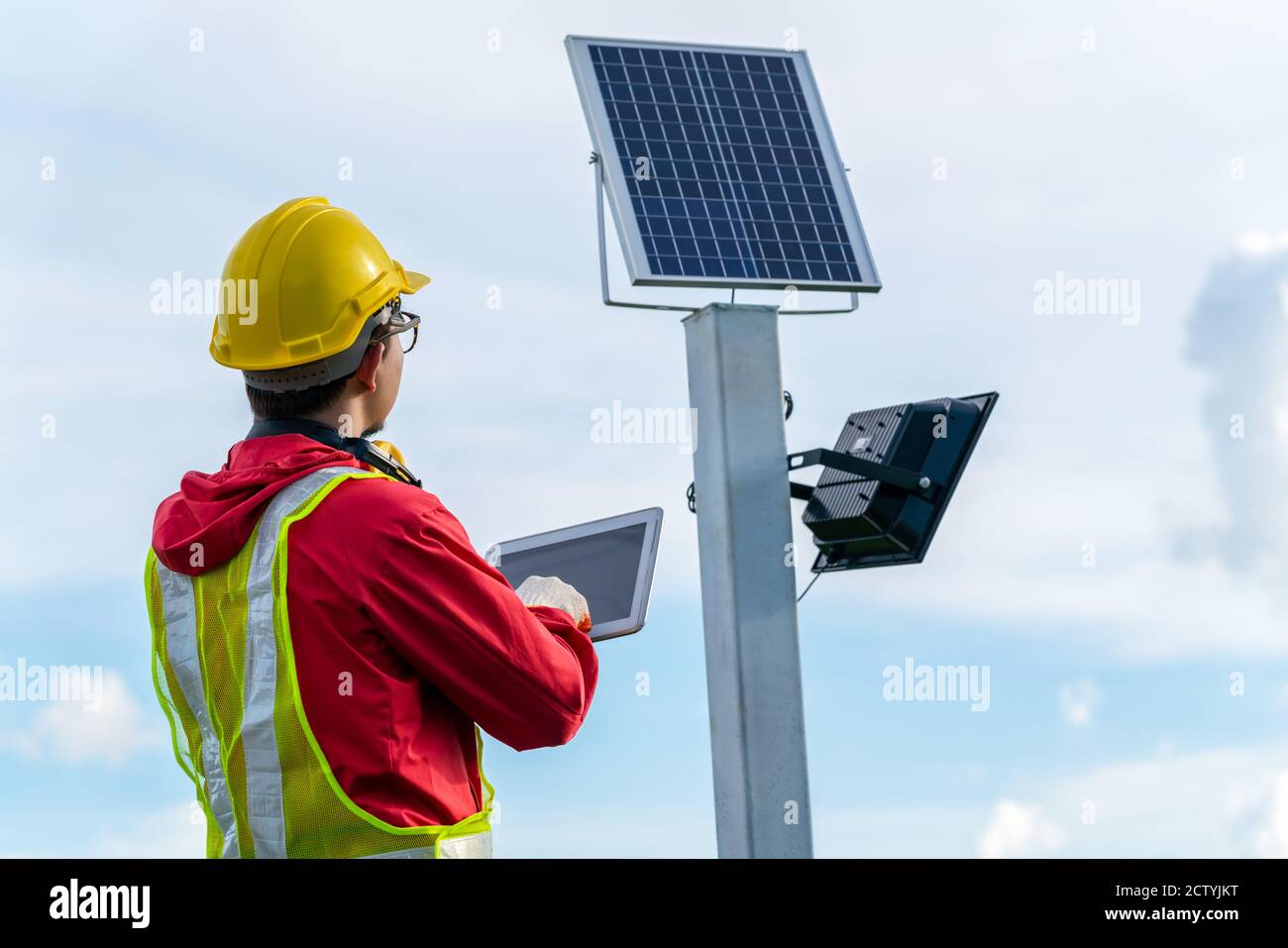 Tecnico asiatico verifica la manutenzione dei pannelli solari, palo per illuminazione esterna con piccola energia solare pannello da parte di themself è nuova tecnologia e ener Foto Stock
