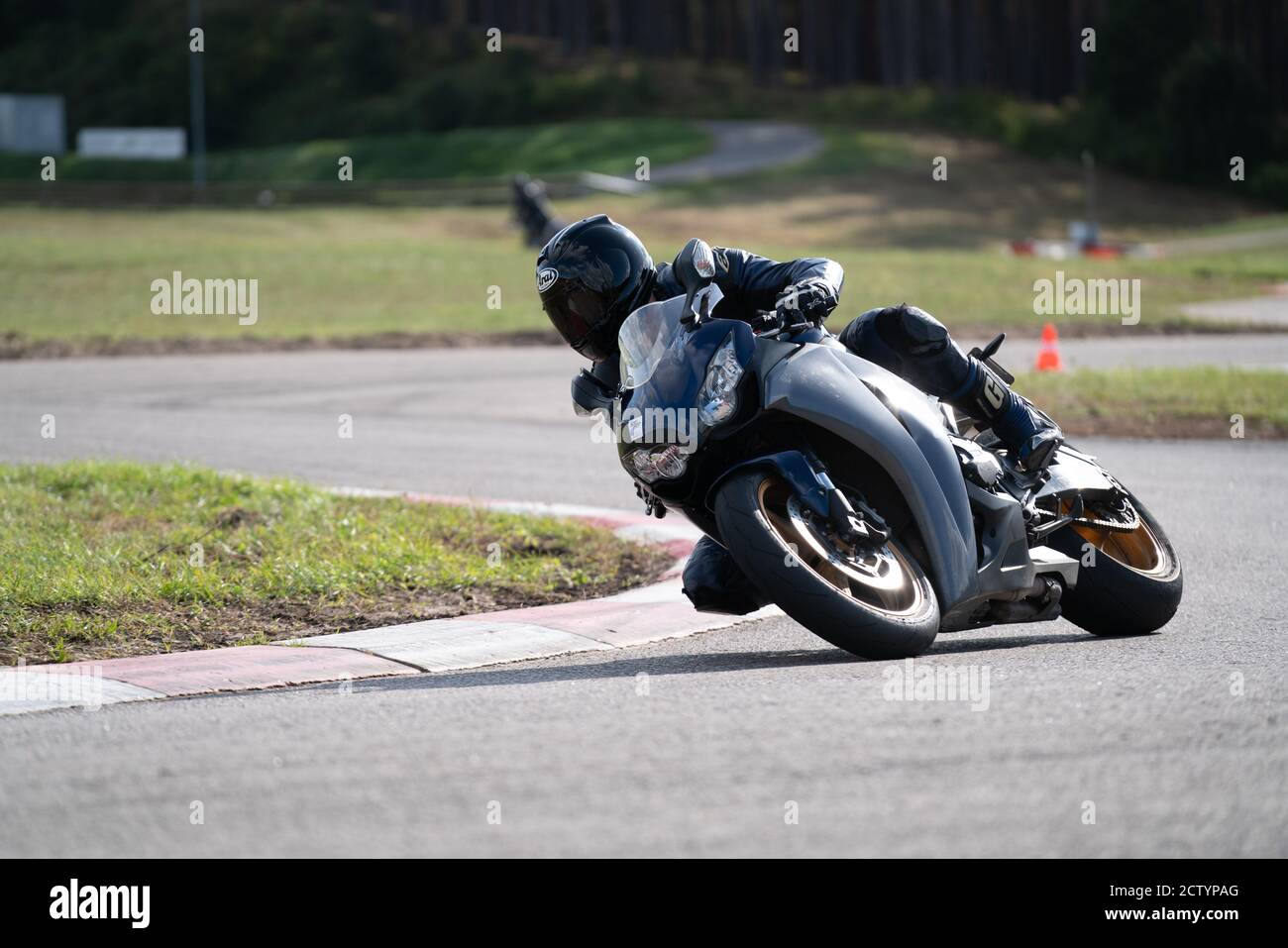 Moto pratica inclinandosi in una curva veloce in pista. Foto Stock
