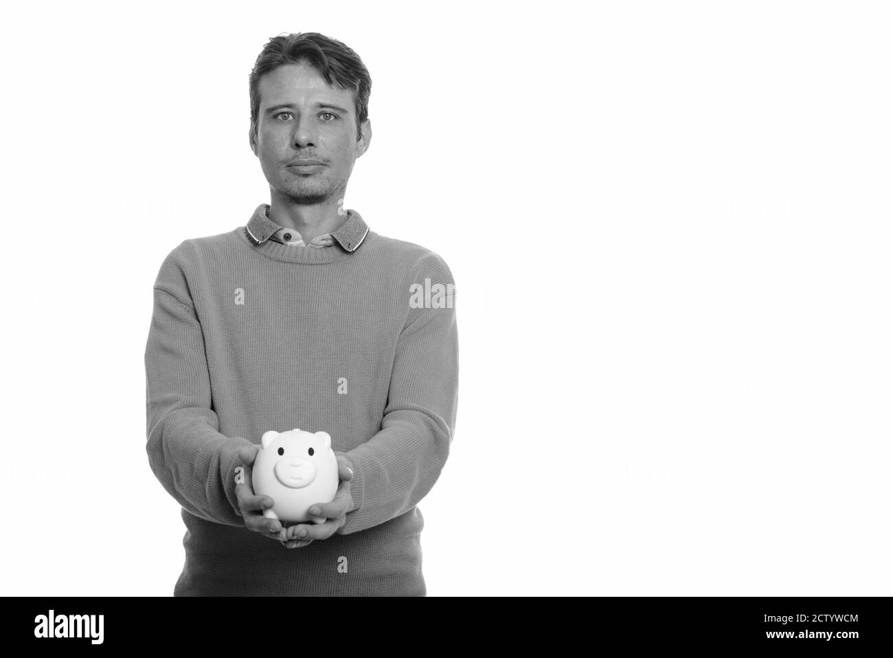 Ritratto di bell'uomo che tiene banca piggy Foto Stock