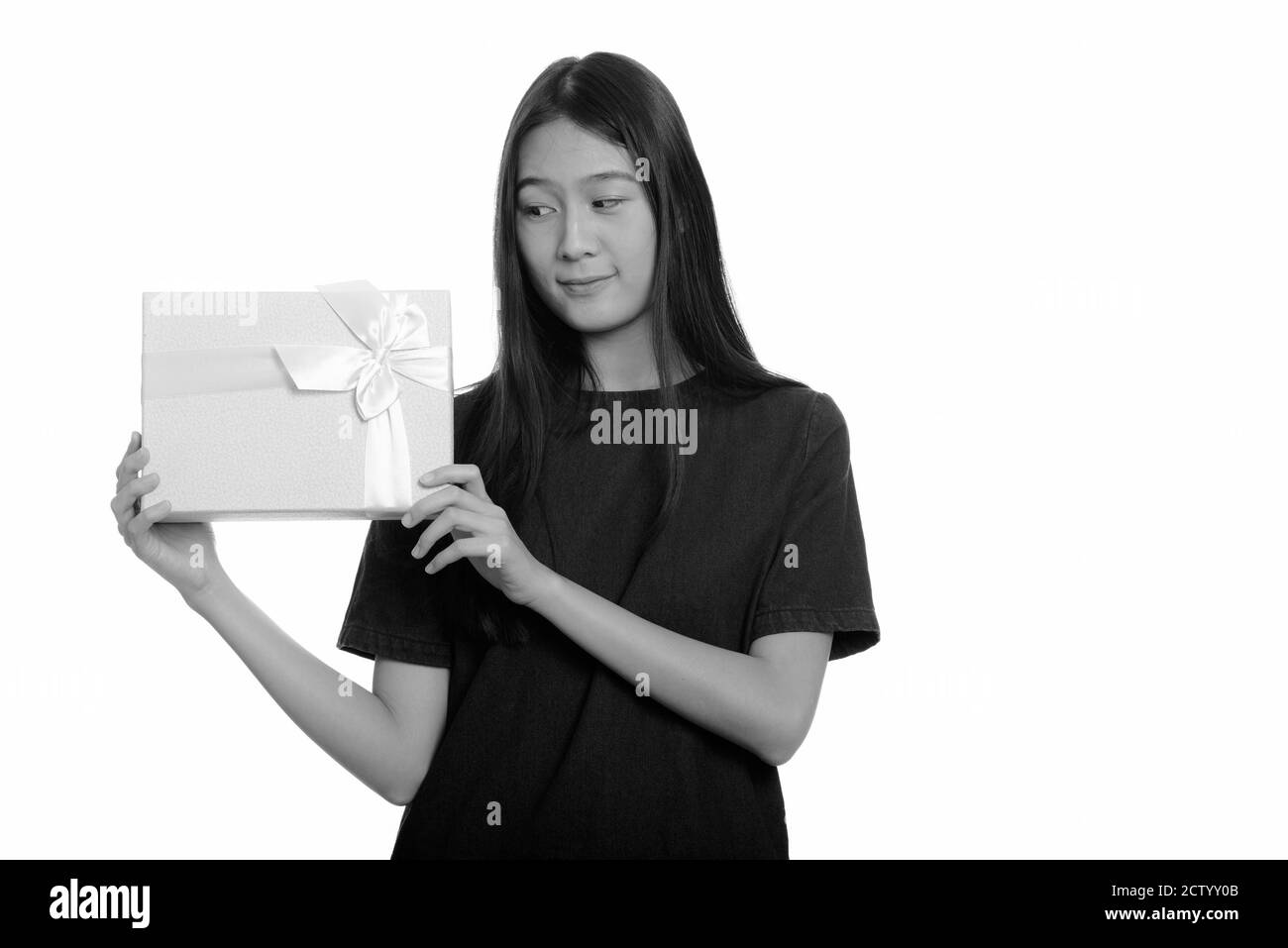 Giovane bella asiatica ragazza adolescente indovinando confezione regalo Foto Stock