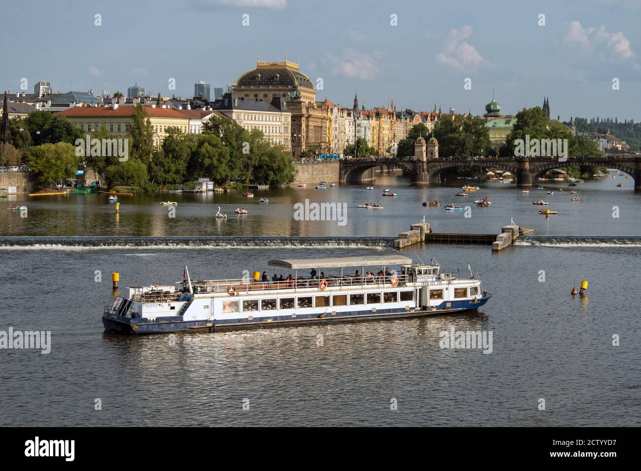 PRAGA, REPUBBLICA CECA: Giro turistico in barca sul fiume Moldava con il Ponte della Legione e il Teatro Nazionale a cupola (Narodni divadlo) sullo sfondo Foto Stock