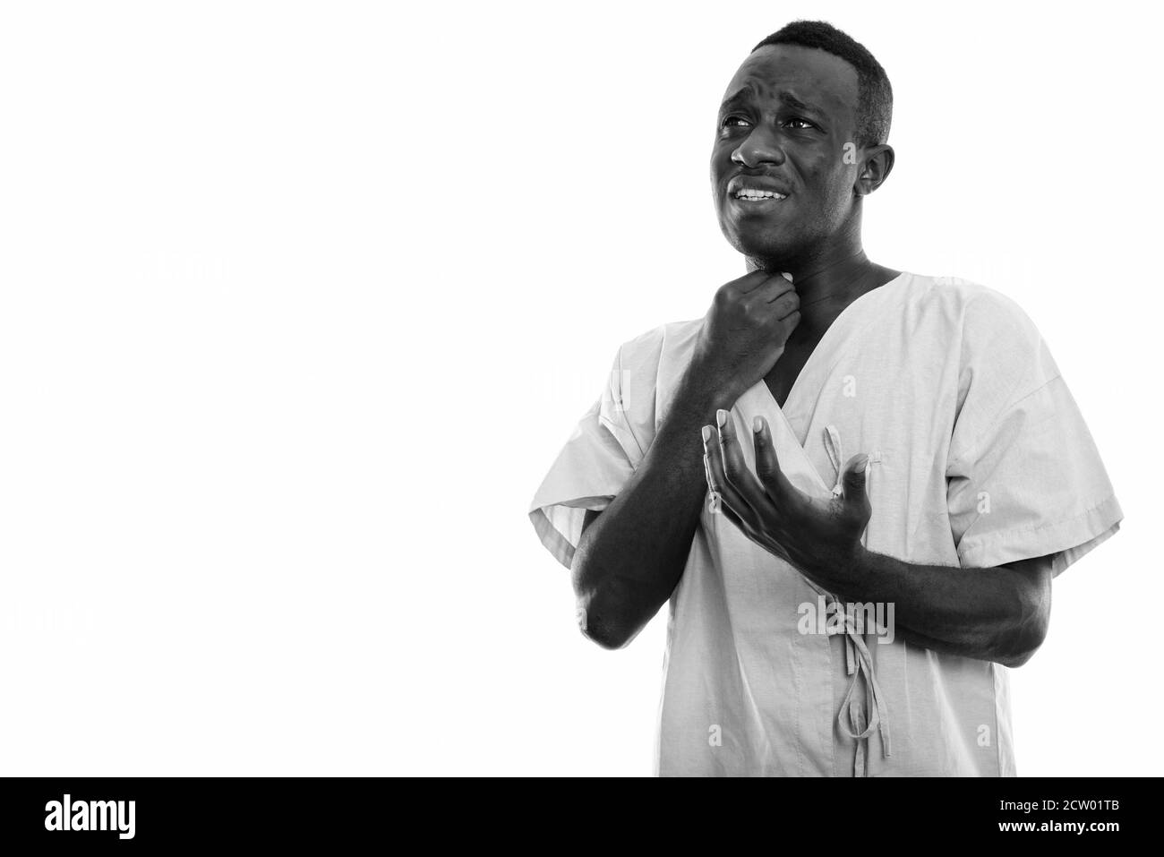 Studio shot del giovane africano nero Uomo di pensiero del paziente mentre lo sguardo triste e avente il mal di gola Foto Stock