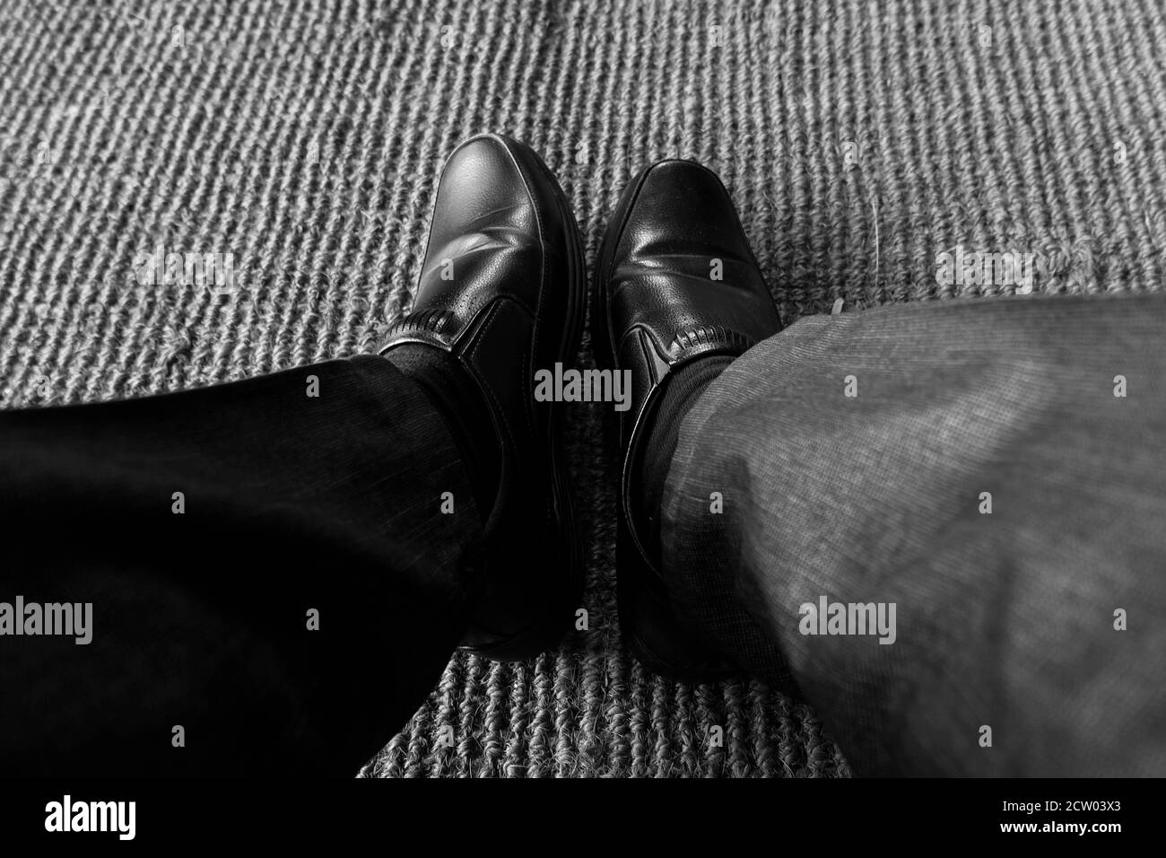 un primo piano di indossare scarpe nere isolate su textured mat Foto Stock
