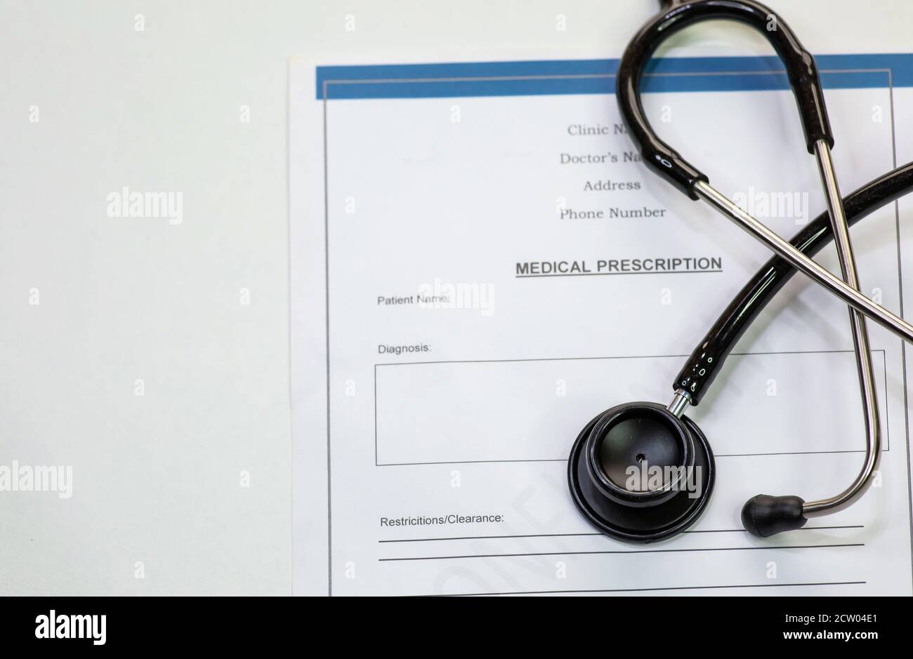 Stetoscopio medico con la forma di prescrizione medica del paziente su sfondo bianco Foto Stock