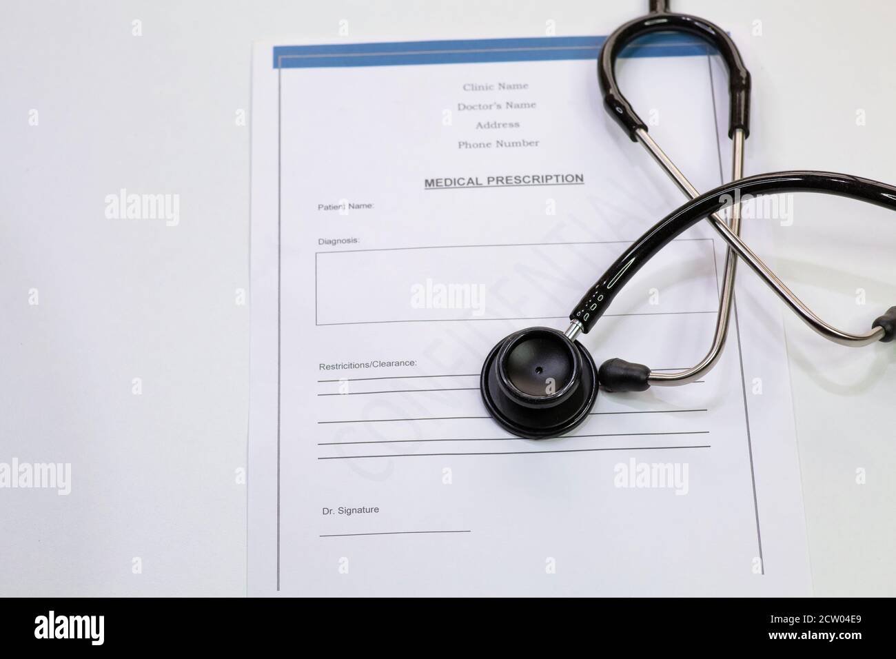 Stetoscopio medico con la forma di prescrizione medica del paziente su sfondo bianco Foto Stock