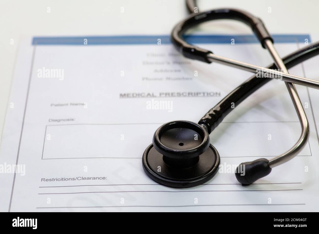 Stetoscopio medico con la forma di prescrizione medica del paziente su sfondo bianco Foto Stock