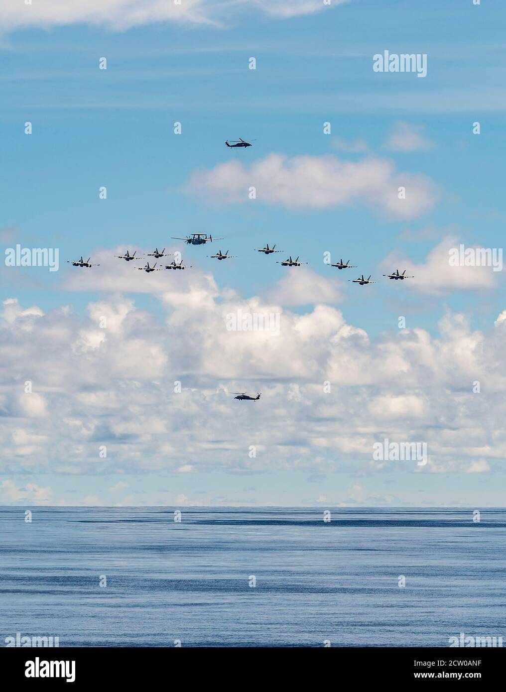 MARE DELLE FILIPPINE (settembre 25, 2020) come visto dalla nave di atterraggio di banchina anfibia USS Germantown (LSD 42), un aereo di allarme aereo e-2 Hawkeye conduce una formazione di F/A-18 Super Hornets mentre volano tra due MH-60S Seahawk elicotteri sopra il Mare delle Filippine. Germantown, parte di Expeditionary Strike Group Seven (ESG 7), insieme alla 31st Marine Expeditionary Unit, opera nell'area di responsabilità della 7esima flotta statunitense per migliorare l'interoperabilità con alleati e partner e funge da forza di risposta pronta per difendere la pace e la stabilità nella regione dell'Indo-Pacifico. (STATI UNITI Navy ph Foto Stock