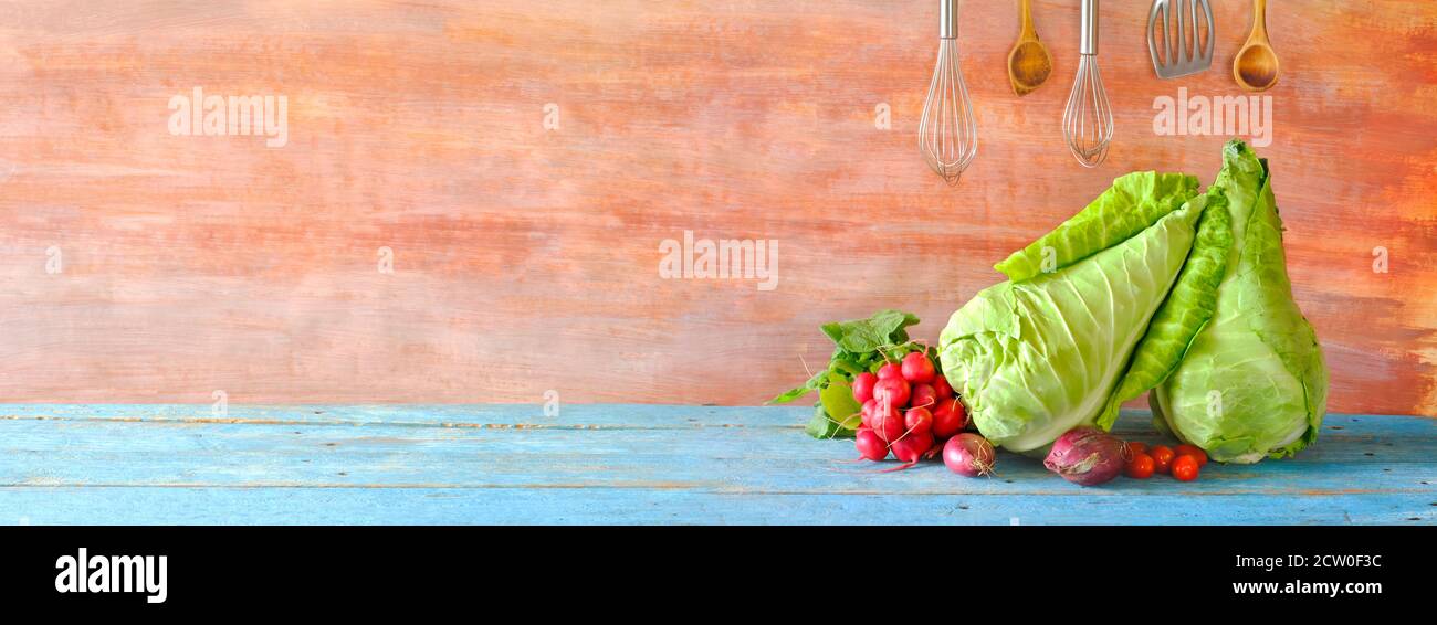 Cavolo dolce, utensili da cucina, pomodori, cipolle, concetto di cucina panoramica con ampio spazio copia. Foto Stock