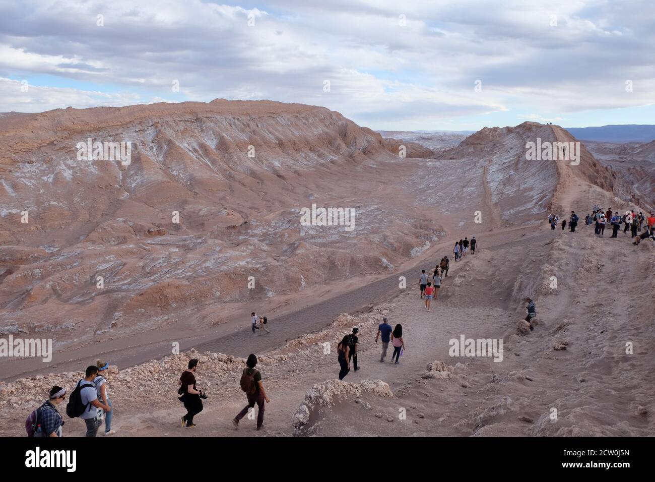 I turisti camminano sul paesaggio lunare del sale incrostato Valle de la Luna, Atacama Foto Stock