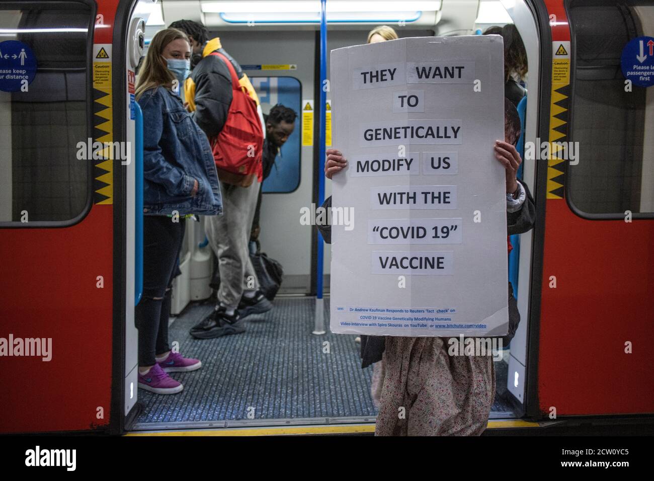 Il protetore della vaccinazione anti Coronavirus viaggia sulla metropolitana di Londra con un cartello, Londra, Regno Unito Foto Stock