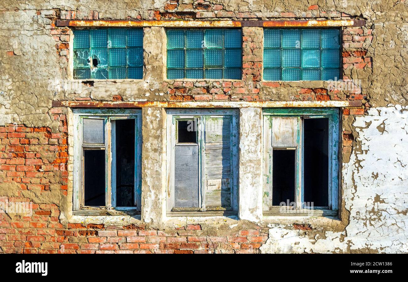 Grunge danneggiato finestre rotte in mattoni rovinato muro edificio Foto Stock