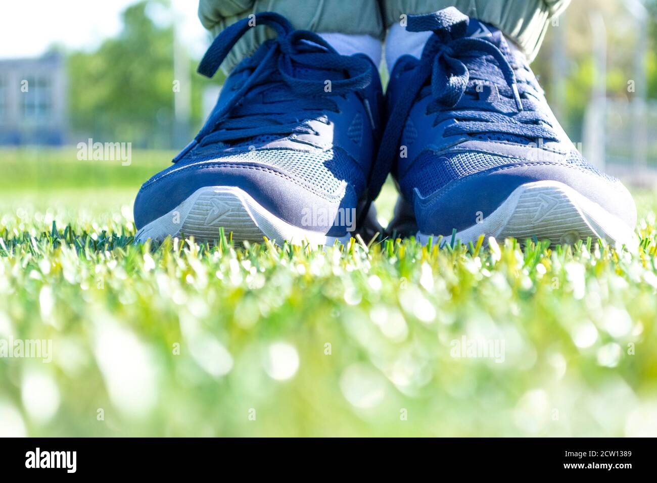 Piedi maschi in sneakers sportive in piedi su erba verde Foto Stock
