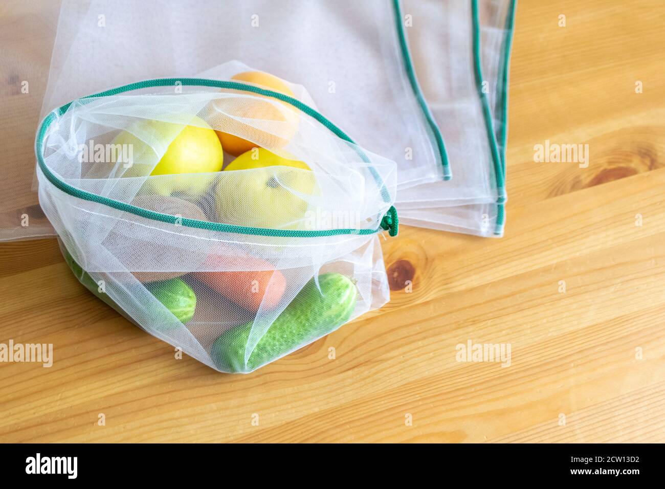 Principio di zero sprechi. Sacchetto di tessuto riciclato privo di plastica per frutta o verdura su una superficie di legno. Foto Stock