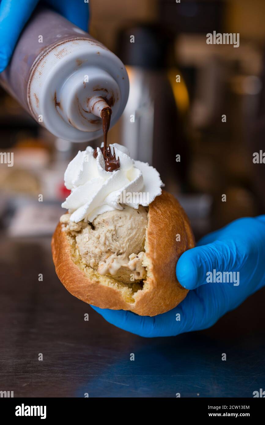 Preparazione artigianale del classico maritozzo italiano, panna dolce, con gelato e panna montata. Foto Stock