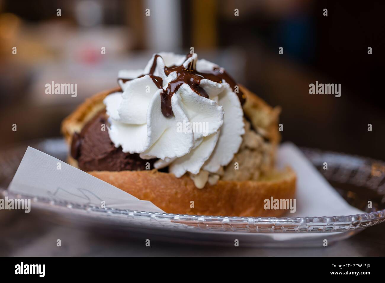 Preparazione artigianale del classico maritozzo italiano, panna dolce, con gelato e panna montata. Foto Stock