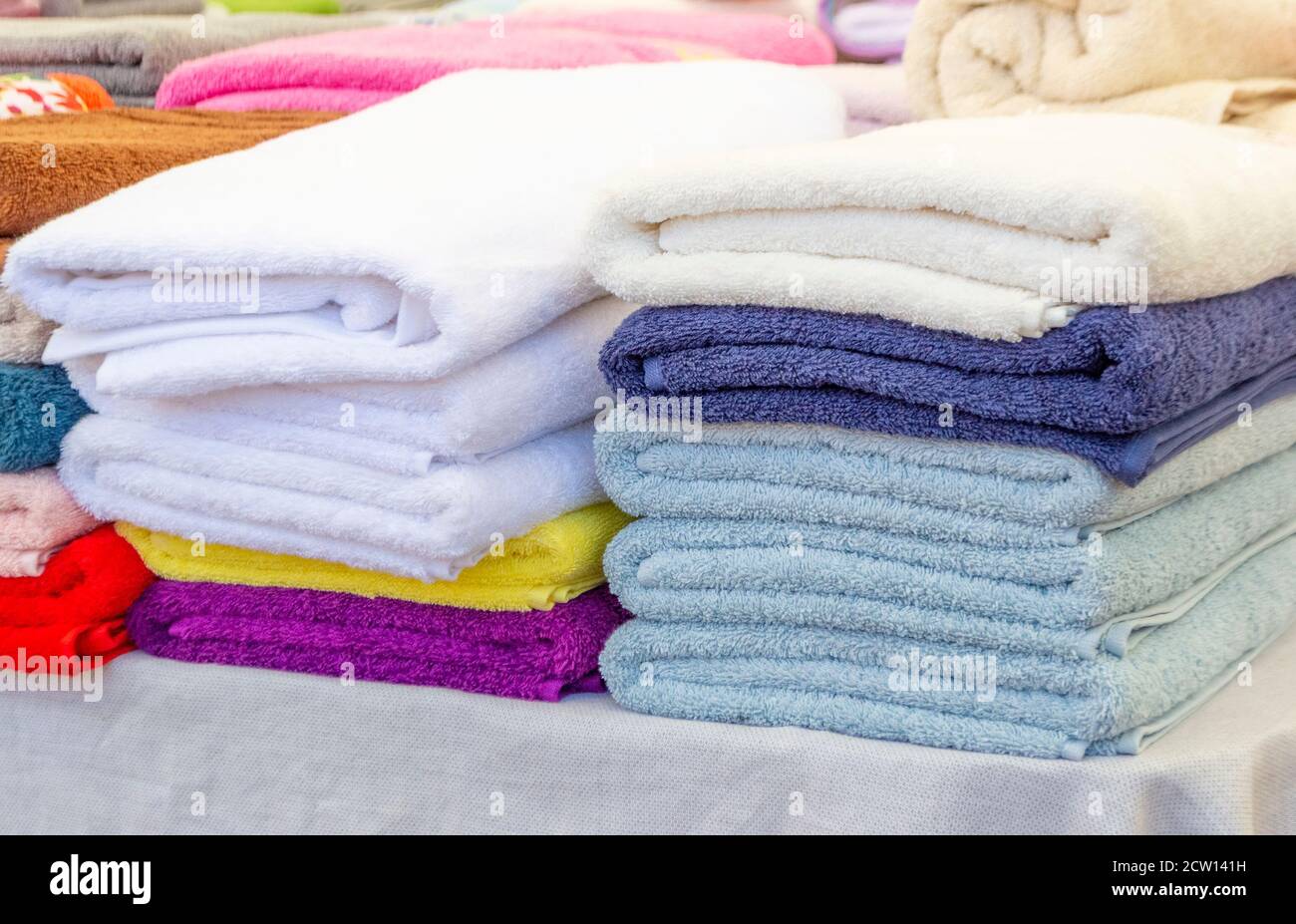 Pila di asciugamani puliti di colore morbido sul tavolo Foto Stock