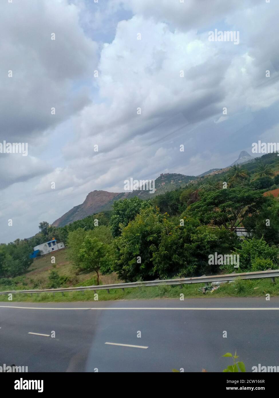 vista sulle montagne e sugli alberi di cocco dal lato della strada Foto Stock