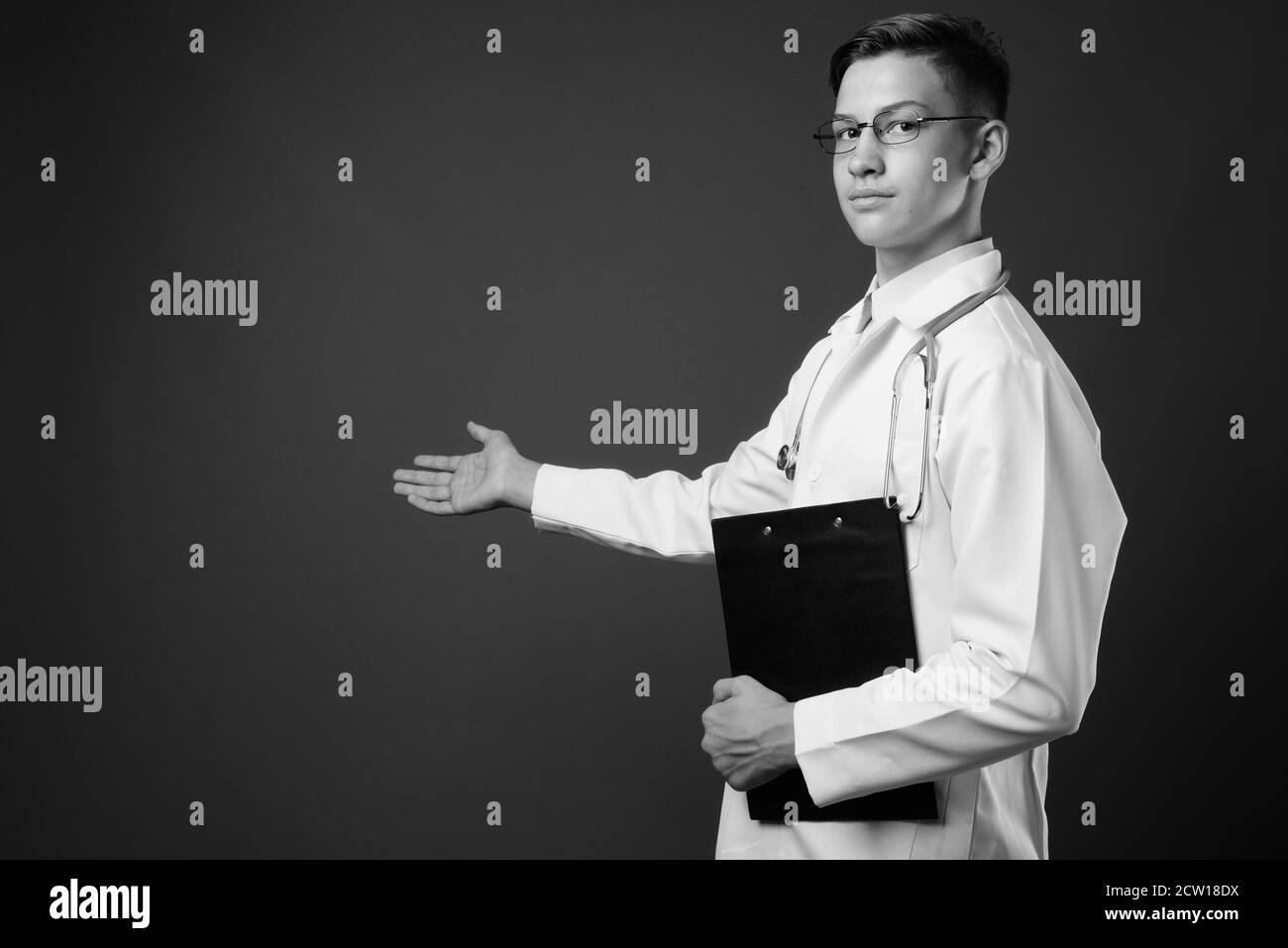 Studio di giovane bel medico su sfondo grigio Foto Stock