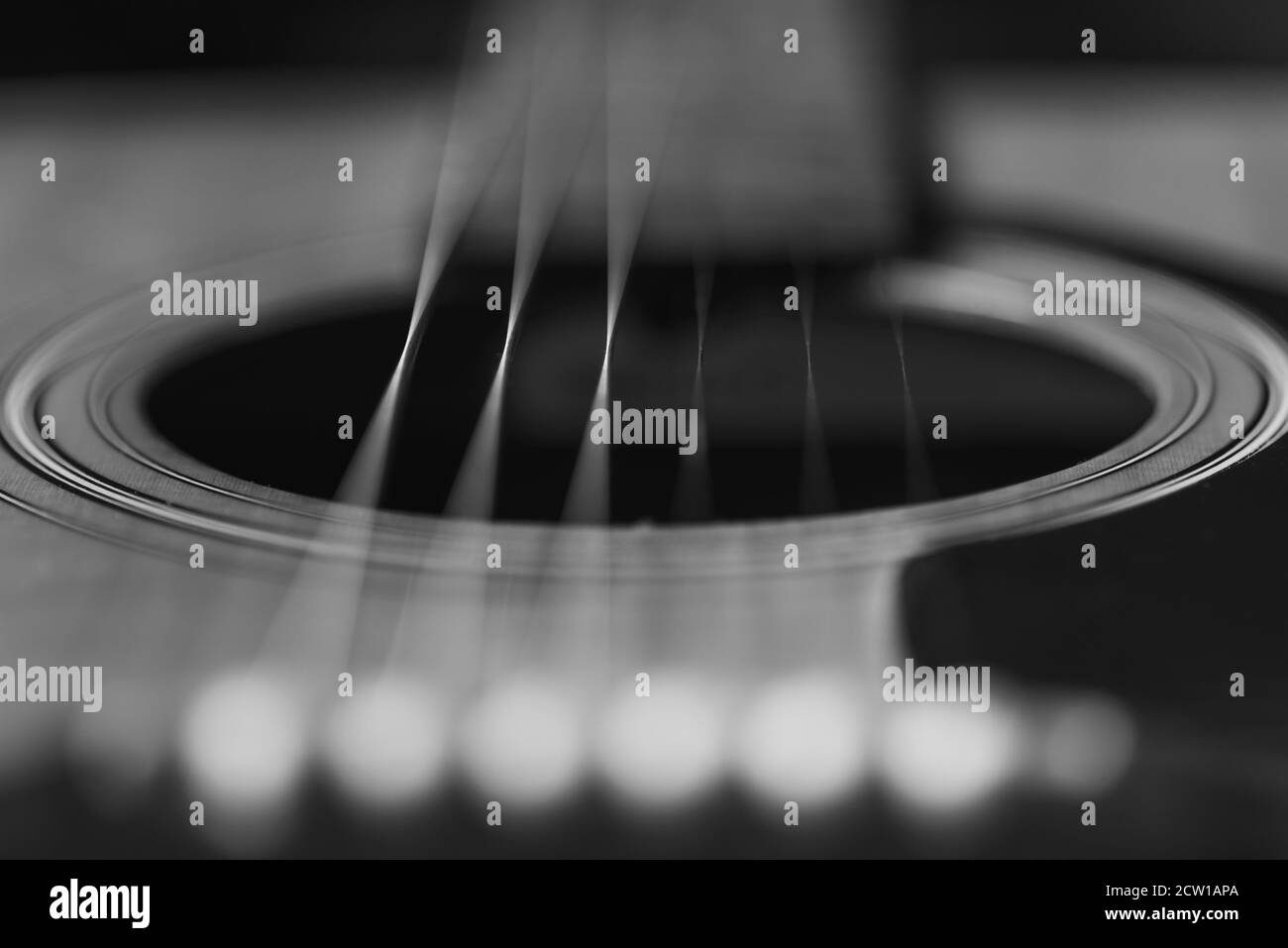 Dettagli di una chitarra acustica, foto dettagliate di una chitarra, corde di chitarra e soundhole, astratto, sfocatura, macrofotografia, bianco e nero Foto Stock