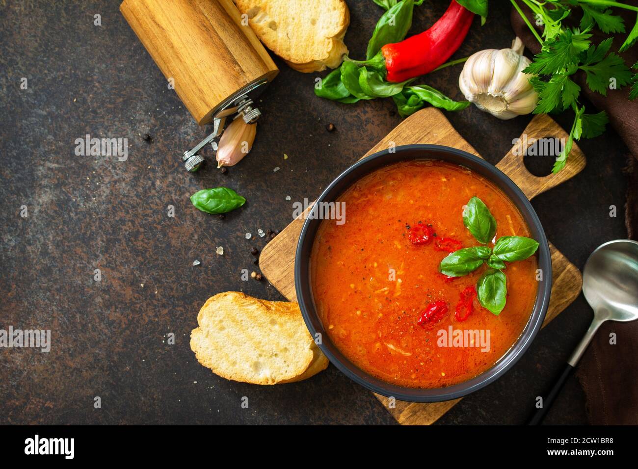 Cibo vegano sano. Zuppa di pomodoro o gazpacho su un tavolo di pietra scura o ardesia. Vista dall'alto in posizione piatta. Spazio di copia. Foto Stock
