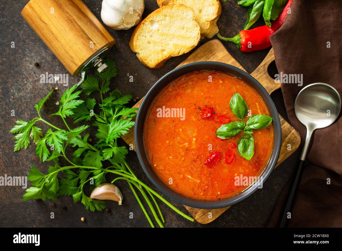Cibo vegano sano. Zuppa di pomodoro o gazpacho su un tavolo di pietra scura o ardesia. Vista dall'alto in posizione piatta. Foto Stock