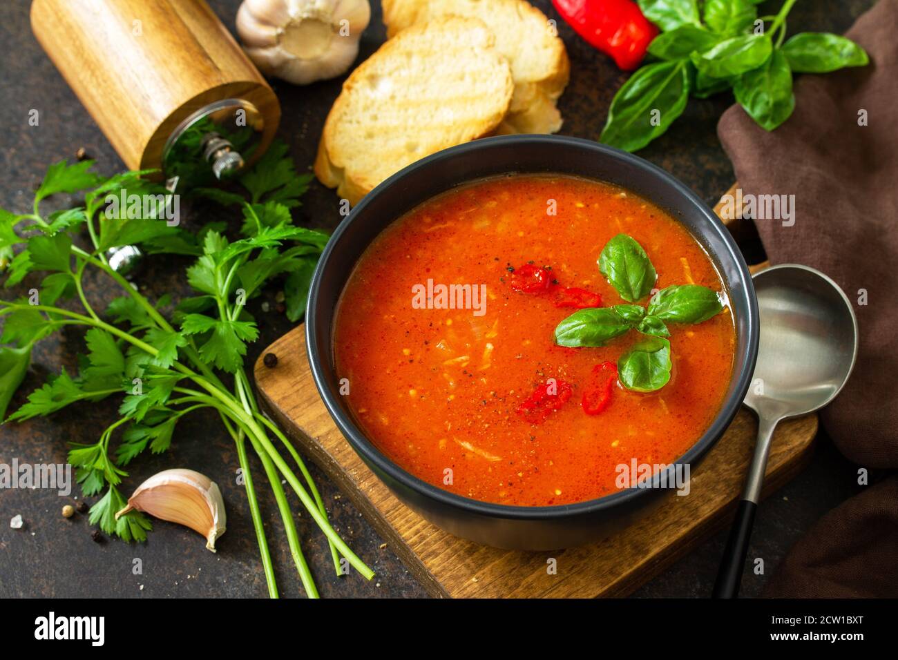 Cibo vegano sano. Zuppa di pomodoro o gazpacho su un tavolo di pietra scura o ardesia. Foto Stock