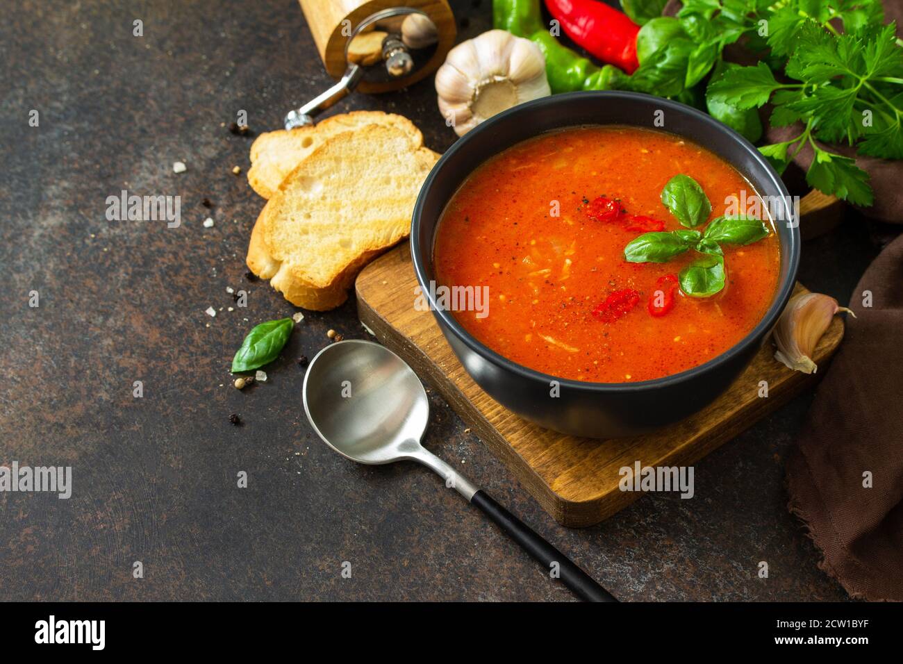 Cibo vegano sano. Zuppa di pomodoro o gazpacho su un tavolo di pietra scura o ardesia. Spazio di copia. Foto Stock