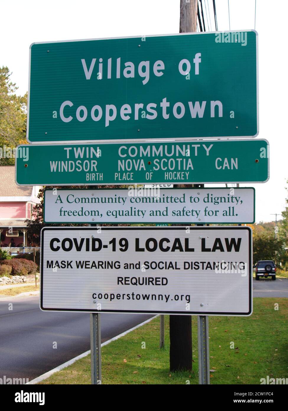 Il segno comunale americano durante il 2020 Covid 19 scoppio dice che l'uso della maschera e l'allontanamento sociale richiesto come da legge locale a Cooperstown, NY Foto Stock