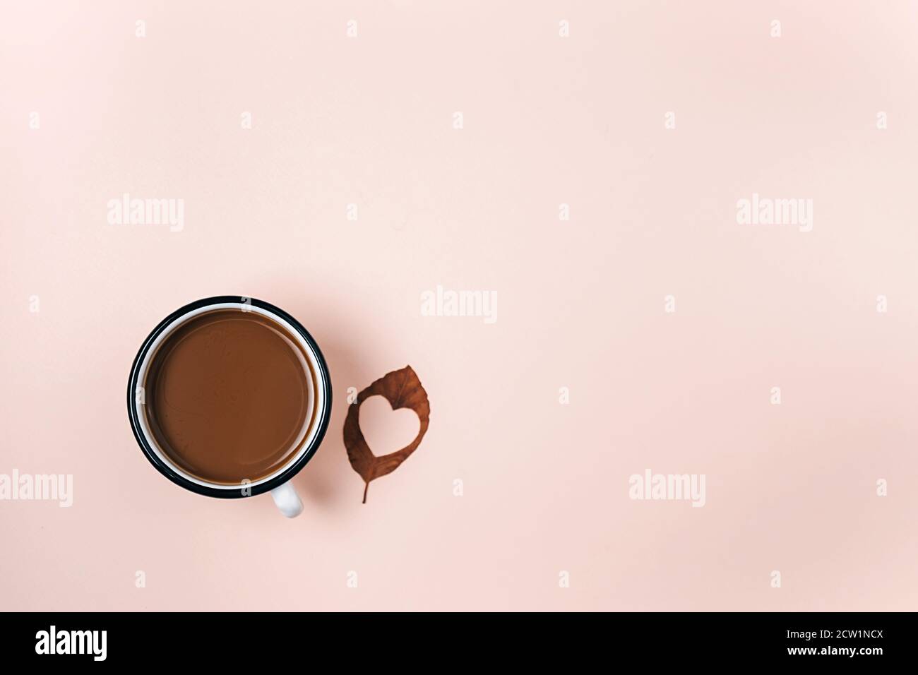 Piatto autunnale di foglia secca con cuore intagliato e tazza di caffè caldo su sfondo di studio beige pastello con spazio di copia per la pubblicità. Ringraziamento, fa Foto Stock