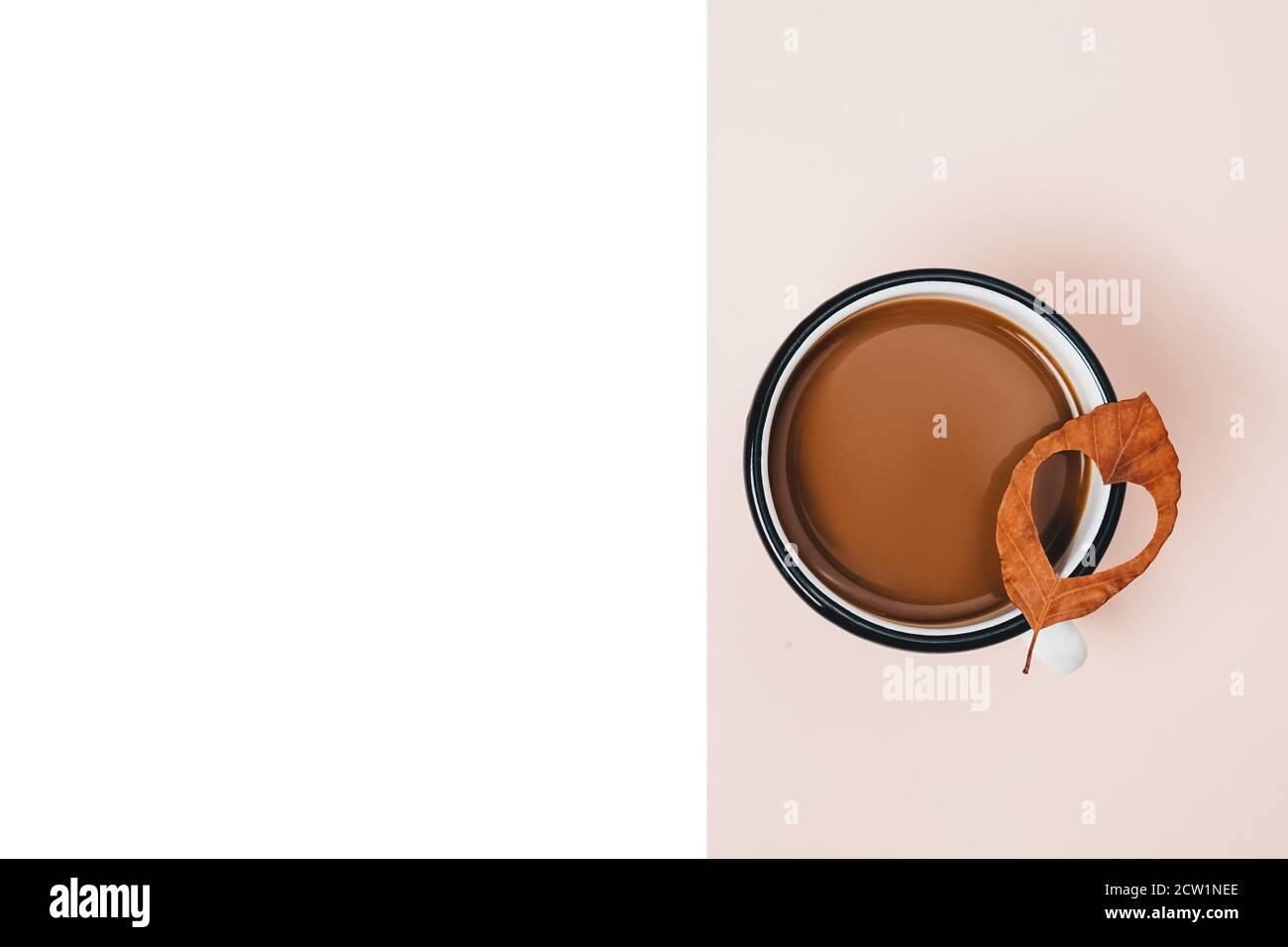 Autunno, giorno di ringraziamento e concetto invernale. Tazza di caffè e foglie secche di forma cardiaca su sfondo bianco e beige studio con spazio di copia per l'addver Foto Stock