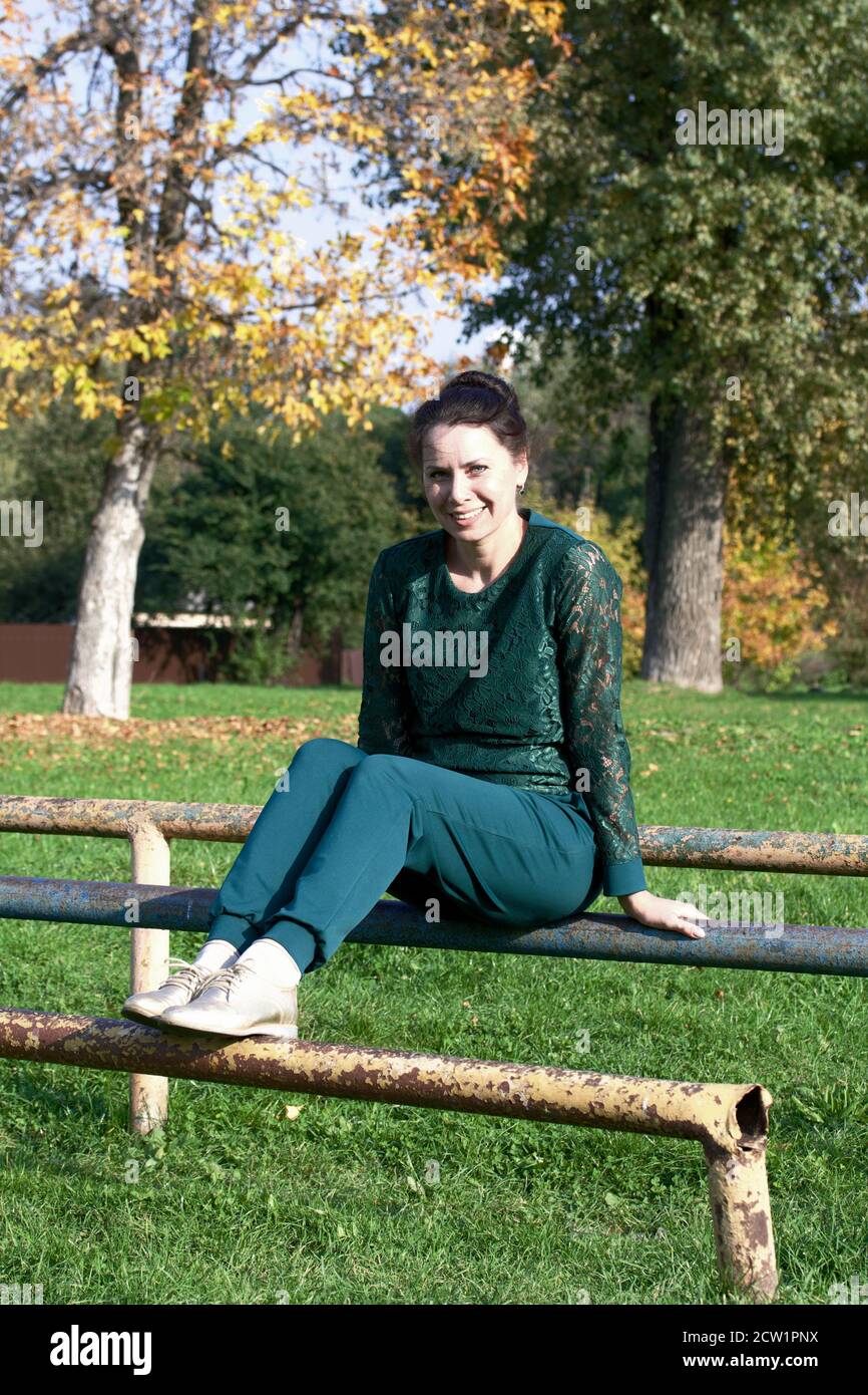 La ragazza in una tuta verde. Su uno Sportsground. Fa esercizio fisico Foto  stock - Alamy