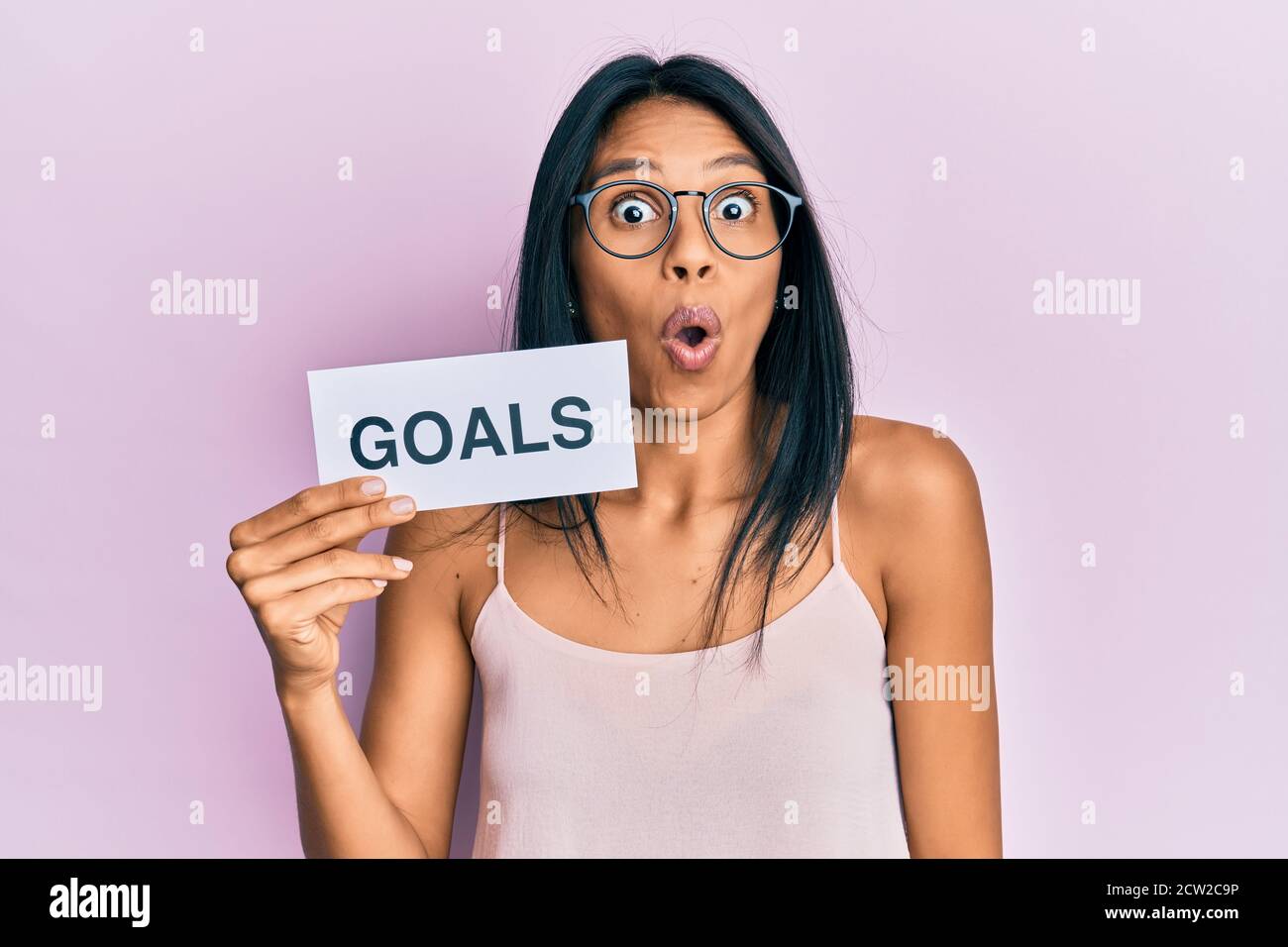 Giovane donna afroamericana che tiene obiettivi messaggio carta spaventato e stupito con bocca aperta per sorpresa, faccia incredula Foto Stock