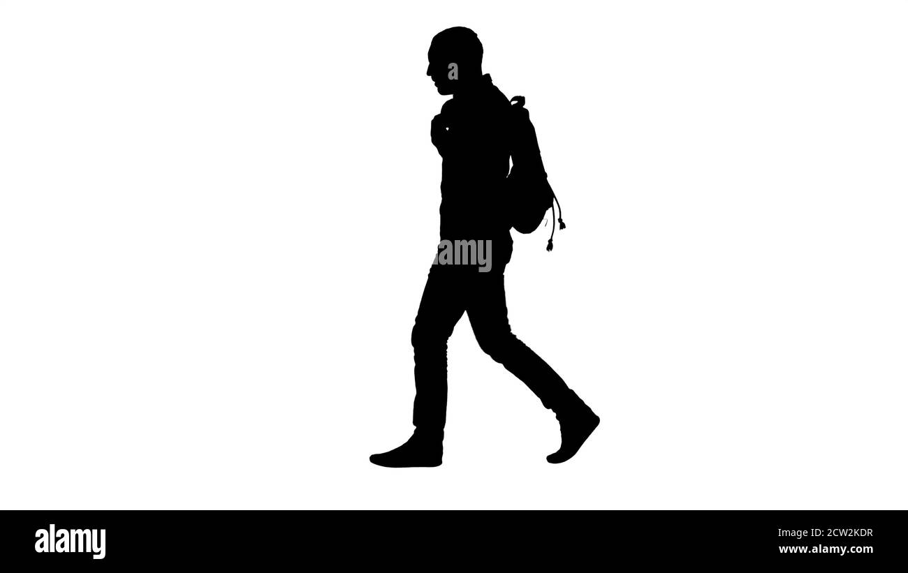 Silhouette giovane studente maschile camminando su isolato backgrou verde Foto Stock
