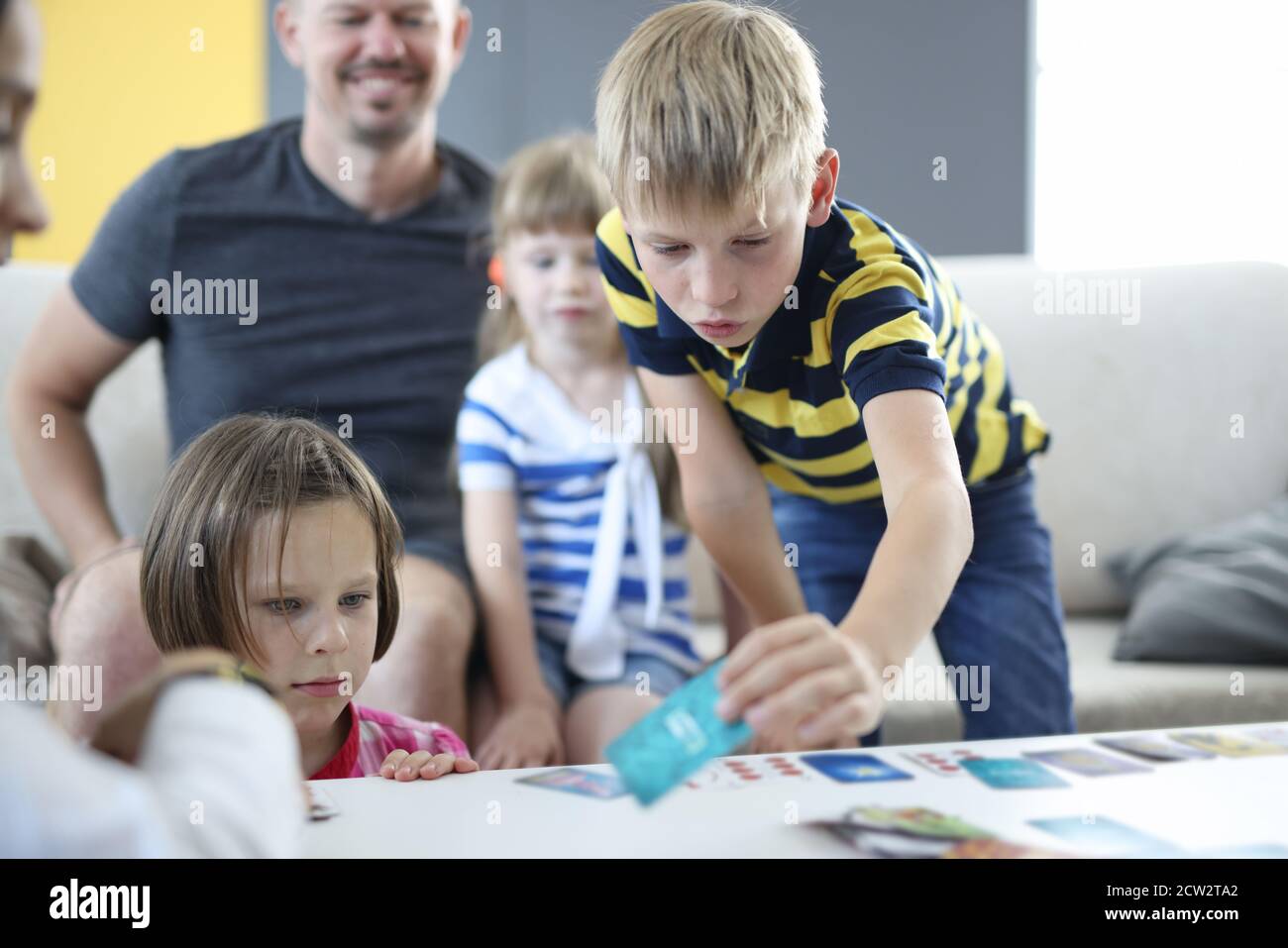 L'uomo con i bambini gioca a giochi da tavolo a casa. Foto Stock