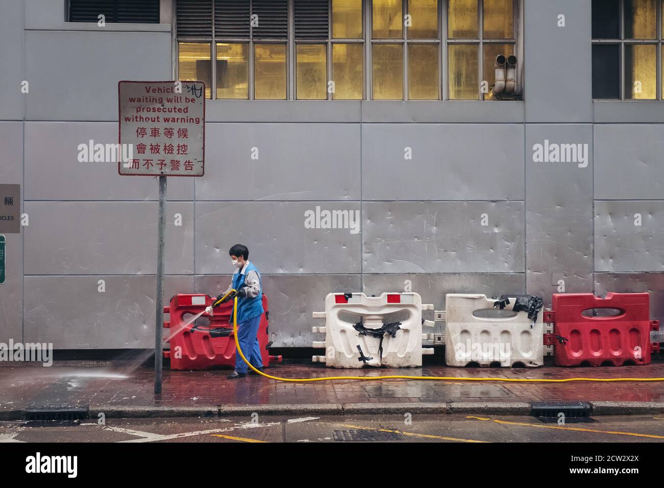 HONG KONG - MAR 09, 2019 : operaio spazzatrice stradale pulizia della strada e passeggiata laterale con acqua al mattino nel quartiere Jordan di Hong Kong Foto Stock