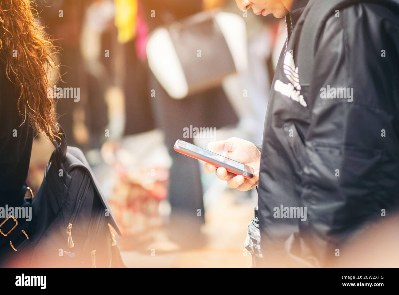 Immagine ravvicinata delle mani maschili che usano lo smartphone di notte sulla via dello shopping cittadino, ricerca o concetto di social network, uomo hipster che digita un messaggio sms Foto Stock