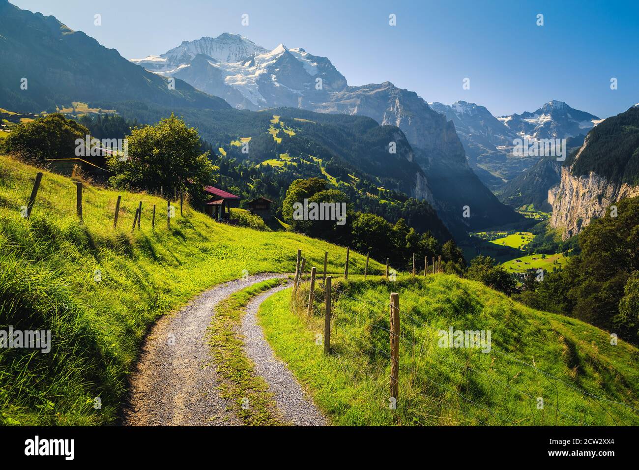Paesaggio alpino mozzafiato con prati verdi e montagne innevate. Villaggio di Wengen e valle di Lauterbrunnen con alte scogliere, Oberland Bernese, Svizzera Foto Stock