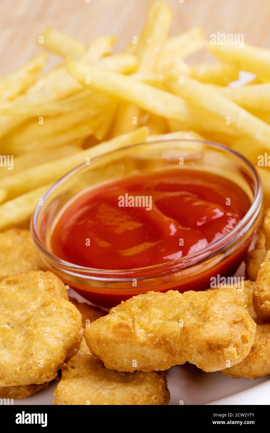 Primo piano di deliziosi pepite di pollo e patatine fritte con ketchup Foto Stock