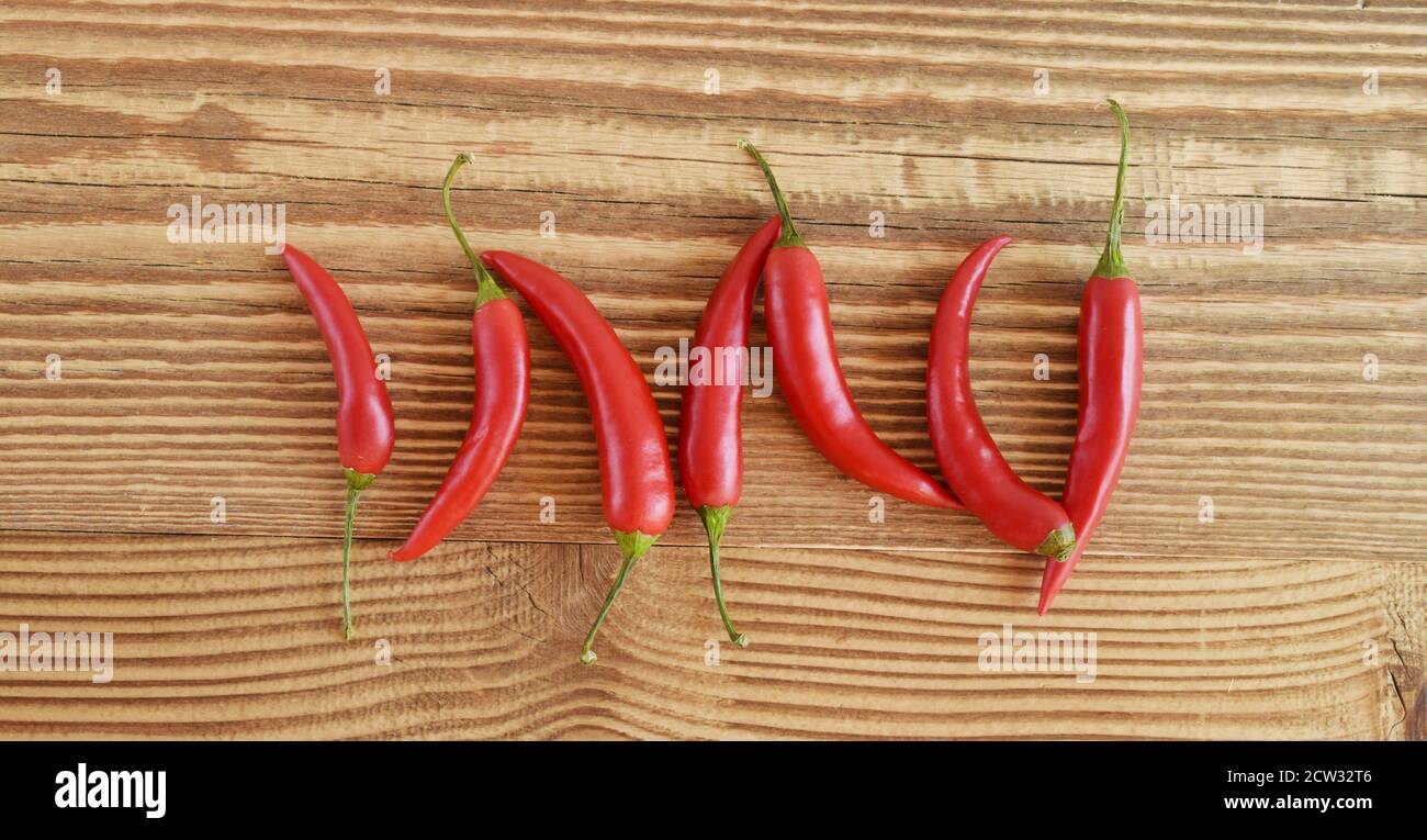 Peperoncino rosso caldo su sfondo di legno. Foto Stock