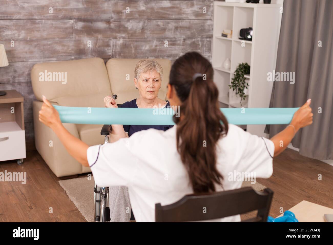 Infermiera che aiuta la donna anziana in sedia a rotelle con riabilitazione. Disabile anziano ricoverato infermiera di aiuto professionale, cura di casa di riposo e riabilitazione Foto Stock