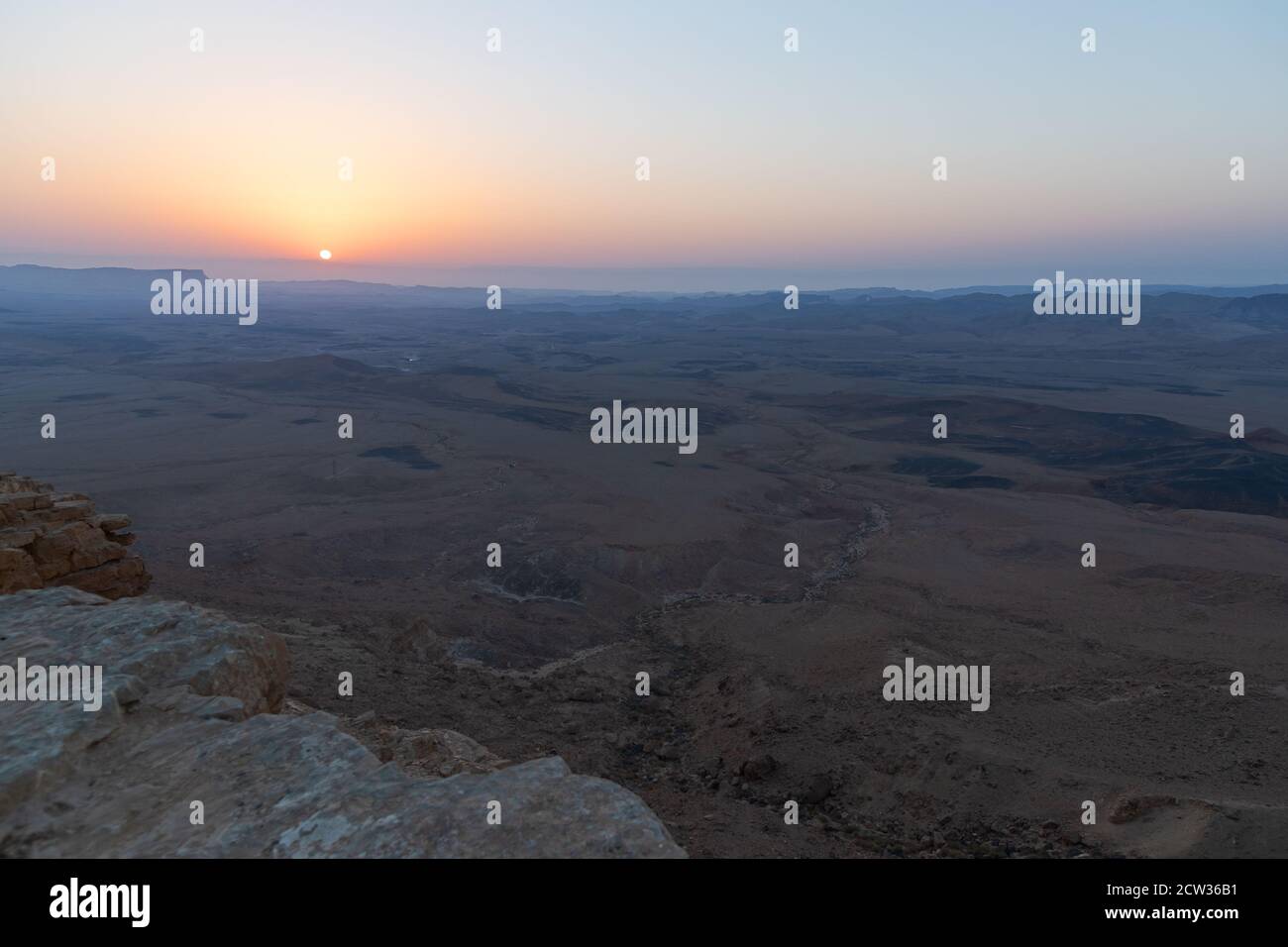 un'alba senza nuvole che mostra la vastità e la geologia di il cratere di makhtesh ramon nel deserto di negev in israele Foto Stock