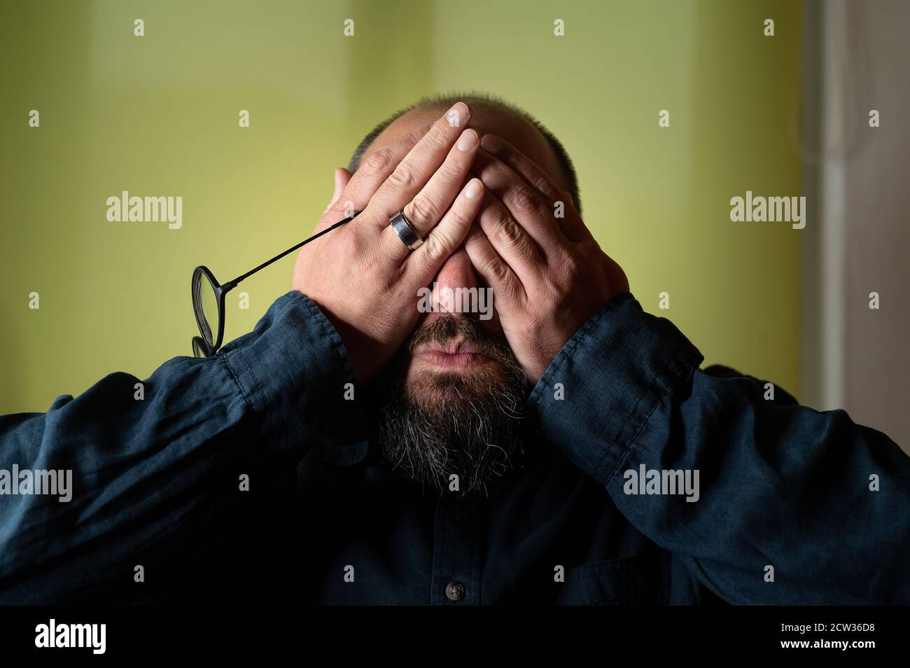 L'uomo nasconde il suo volto dietro le mani così non lo fa deve vedere Foto Stock